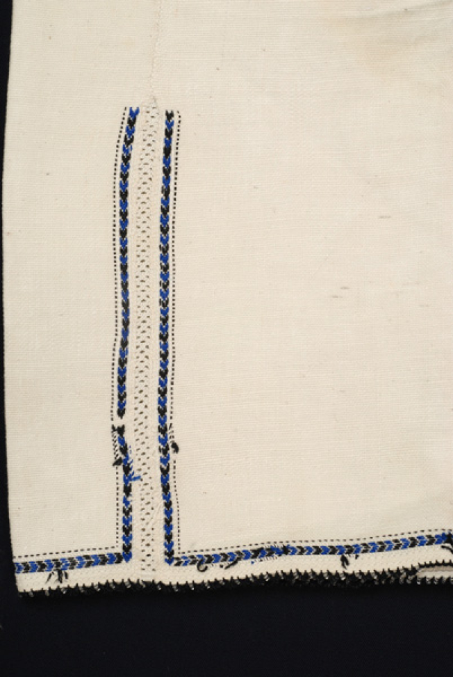 Sleeve, detail of the lacy band of the seam and the embroidered decoration 
