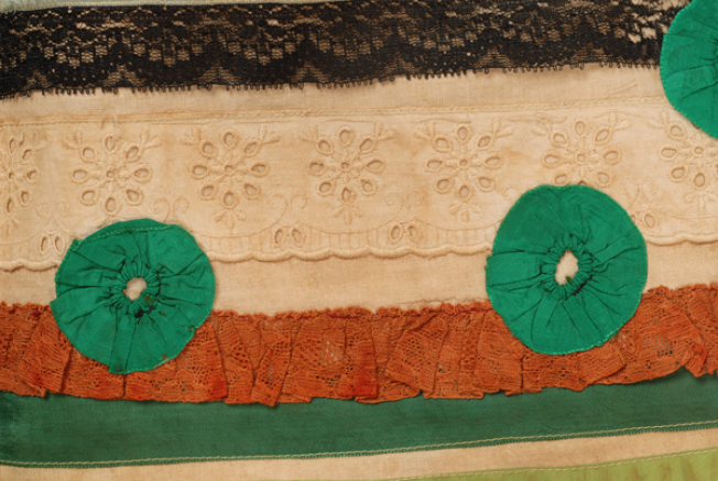 Apron, detail: decoration with rosettes 