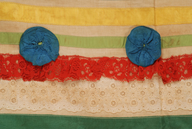 Apron, detail: decoration with rosettes