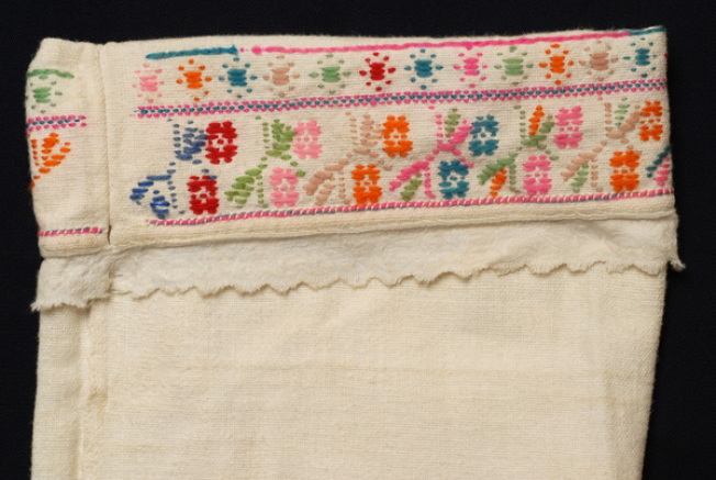 Hem of the sleeves, detail of the decoration with multicoloured flower motifs
