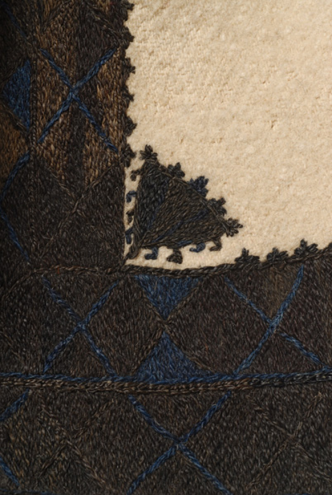 A flower among embroidered bands with brown thread
