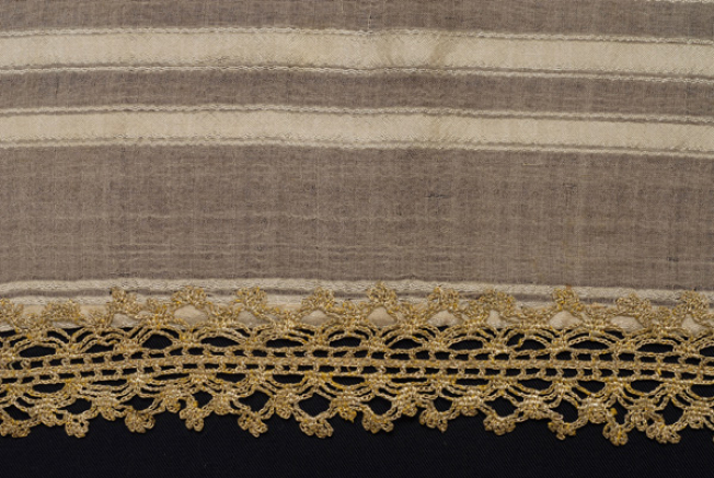 Edge of bolia, detail of the applique decoration with gold lace crafted with embroidery needle