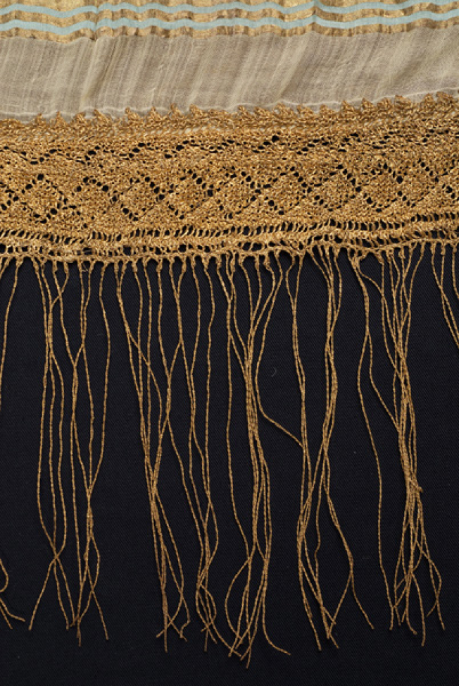 Detail of the applique decoration with gold lace and fringed end
