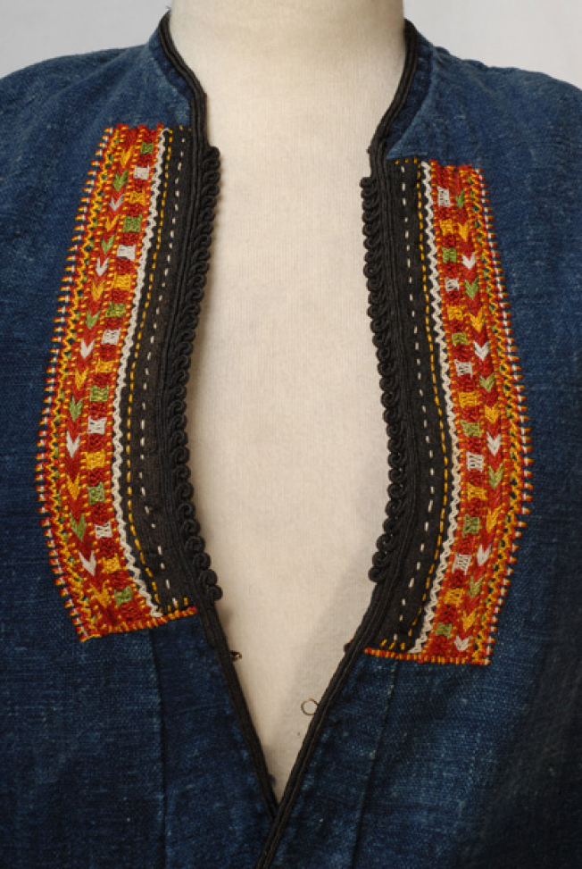 Detail at the chest level, embroidered parallelogram bands
