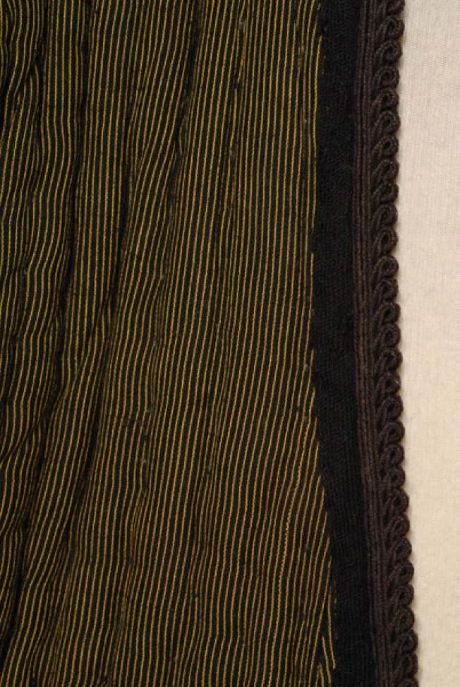 Detail of the inweave and the applique decoration at the chest