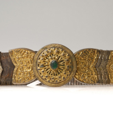 Articulated belt with circle central protrusion with applique wiry decoration and a green stone at the centre