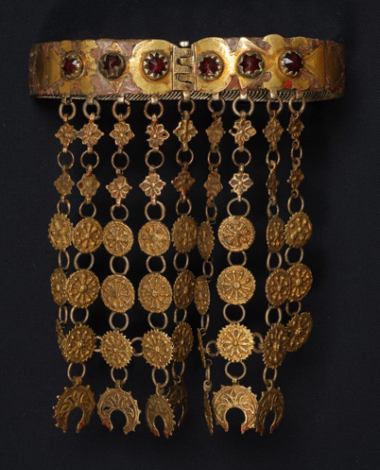 Assimoyordano, choker made from gilt filigree netting decorated with gold-plated foils whose shape is reminiscent of vegetal (stylized tree) and mythical themes (doube-headed eagle). It has suspended elements including flowers, rosettes and petals