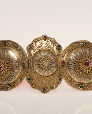 Kolania, gold plated chape ornamented with fine wiry decoration and coloured glass stones
