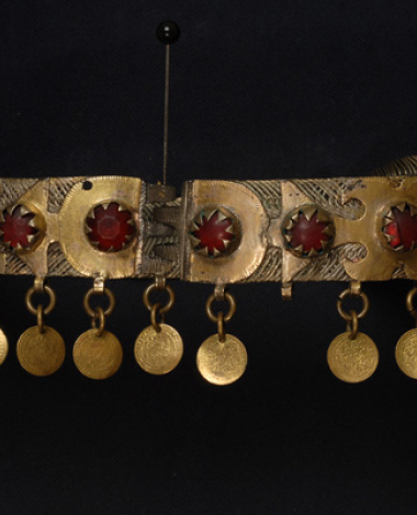 Assimoyordano, choker made of gilt filigree netting decorated on its right side with gold-plated foils whose shape is reminiscent of vegetal (stylized tree) and mythological themes (two-headed eagle), with red glass stones and suspended gilded coins. (Macedonia, Roumlouki)