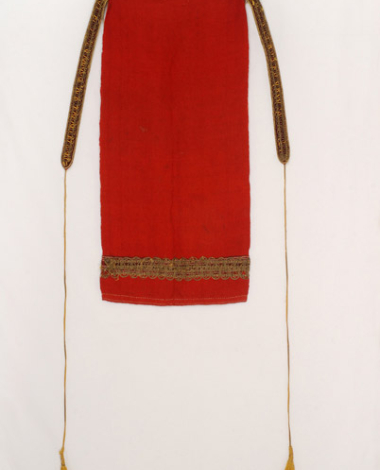 Handwoven red wool apron with embellished stripes at the bottom. The applique decoration with the gold fillet is a later addition