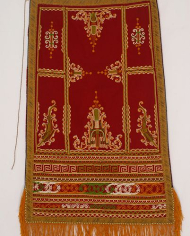 Red felt apron with fringed end and embroidered with colourful outres (cordons)
