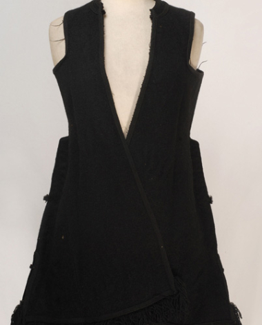 Sleeveless exterior overcoat made of black horse cloth, ornamented with plain coloroured cordons and with woollen fringes