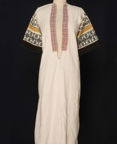 Chemise made of white cotton cloth of the loom with white embroideries at the border and the sleeves with geometrical and stylized vegetal motifs.