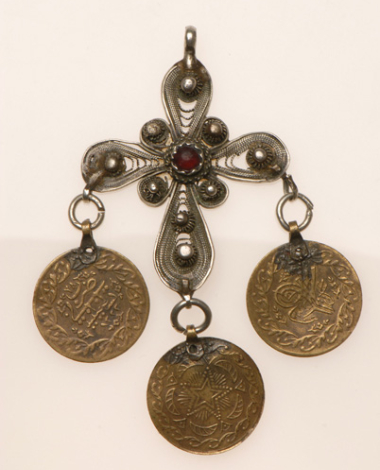 Silver filigree cross decorated with a red glass stone