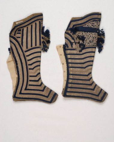 Touzloukia, pair of leggings made of white sayiaki (fullen wool fabric), impressively ornamented with rows of silver braids switching with blue silk cordons (right side)